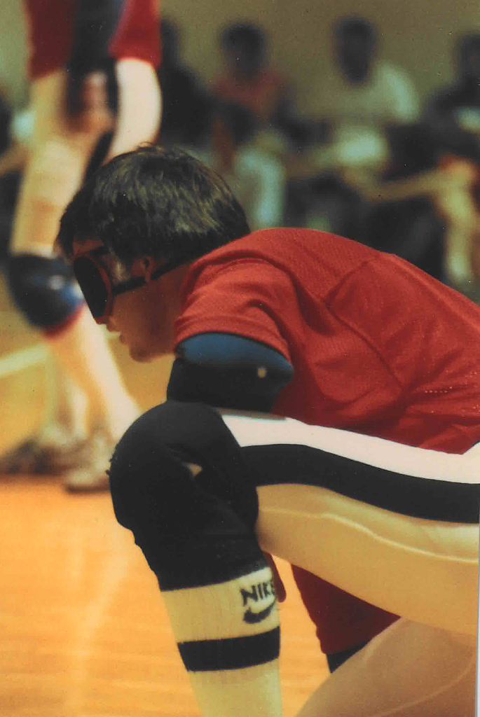 Reni Jackson wears eyeshades as he kneels on one knee while anticipating an opponent's throw