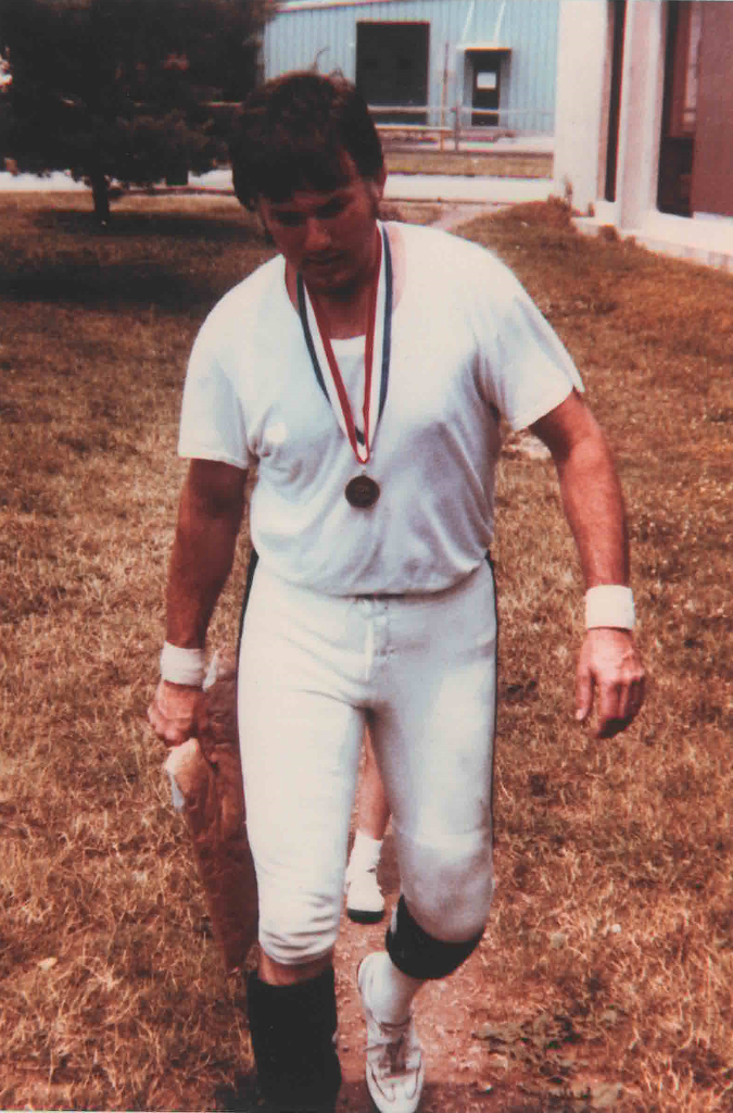 Reni Jackson walks outside in an undershirt wearing his gold medal after giving his USA jersey to a young fan