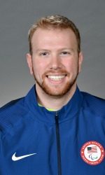 A headshot photo of Andy Jenks wearing a blue United States Paralympic Team jacket.