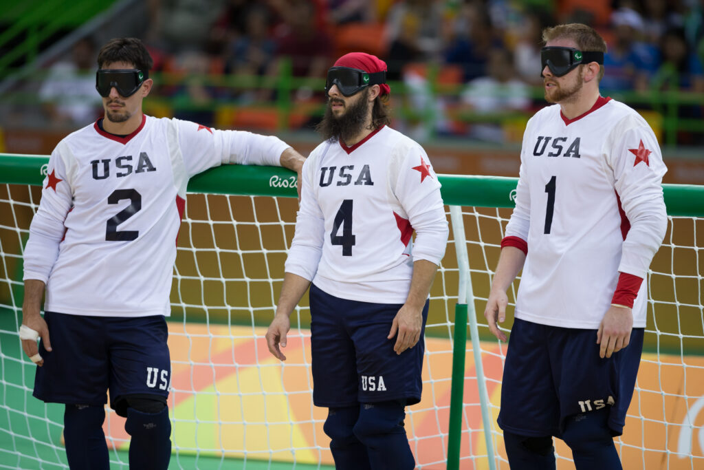 Tyler Merren, John Kusku and Joe Hamilton stand together in front of the goal