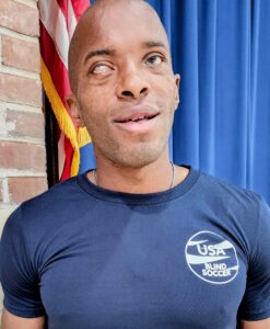 A photo of David Brown wearing a blue USA Blind Soccer t-shirt.