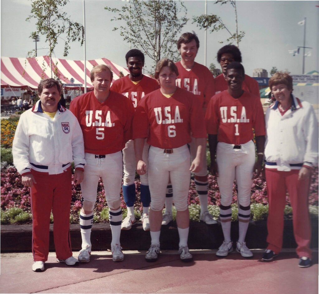The 1984 USA Goalball men's team poses in their uniforms outside.