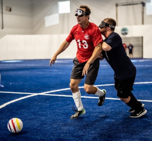 Kevin Brown controls the ball as he dribbles down the field while defender Noah Beckman attempts to knock him off the ball.