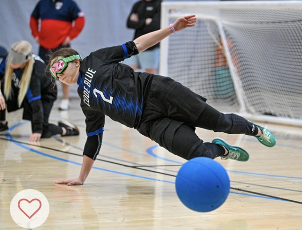 Megan Jenson balances on her right hand as she elevates her body to make a stop during a goalball game