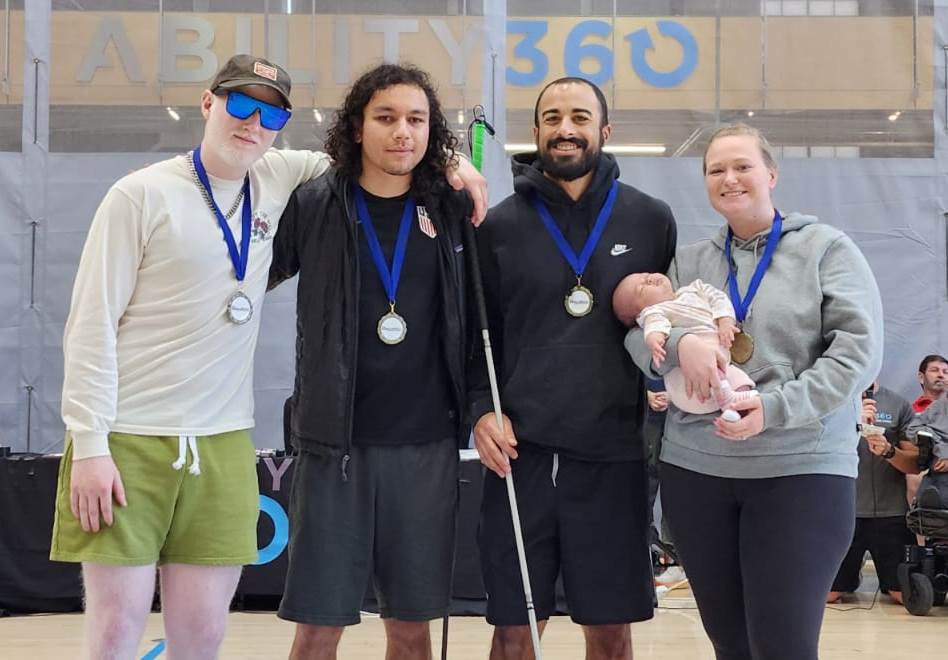 Gold-medal-winning Manticores (l to r): Josh Welborn, Jordan Main, Zach Buhler, Coach Bailey Buhler and baby Buhler