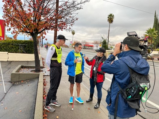 Ramiro Contreras and his guide runner do a live interview at the California International Marathon in December.