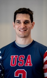 A headshot photo of Tyler Merren wearing a blue USA jersey.