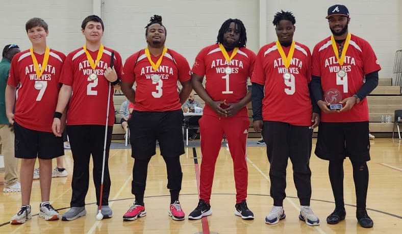 The Men's B Division champion Atlanta Wolves pose on the court with their medals