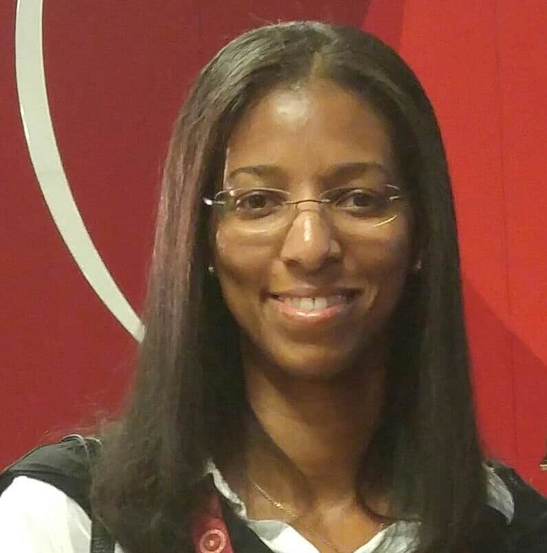 A headshot of Jennifer Demby wearing glasses and smiling for the camera.